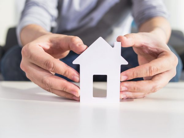 businessmen hold house model in hand